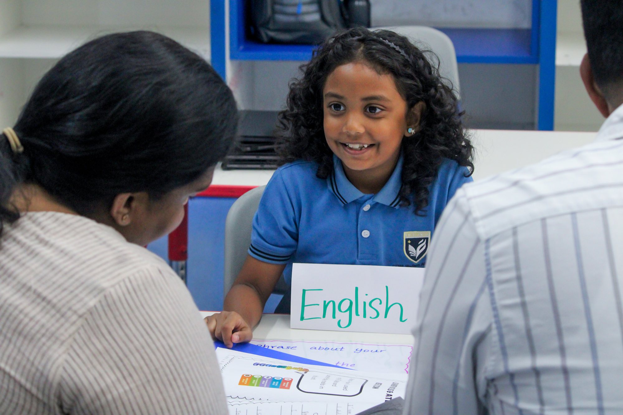 A young student smiling at an English lesson table