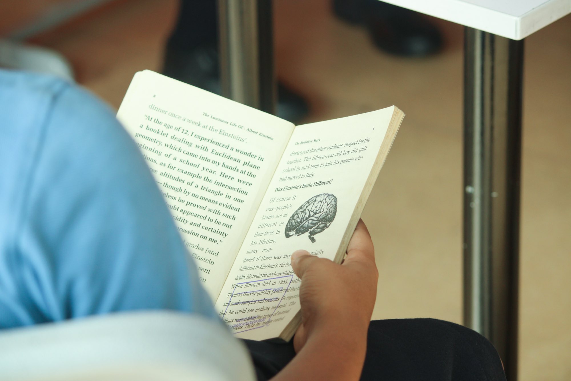 A student reading a book about Albert Einstein