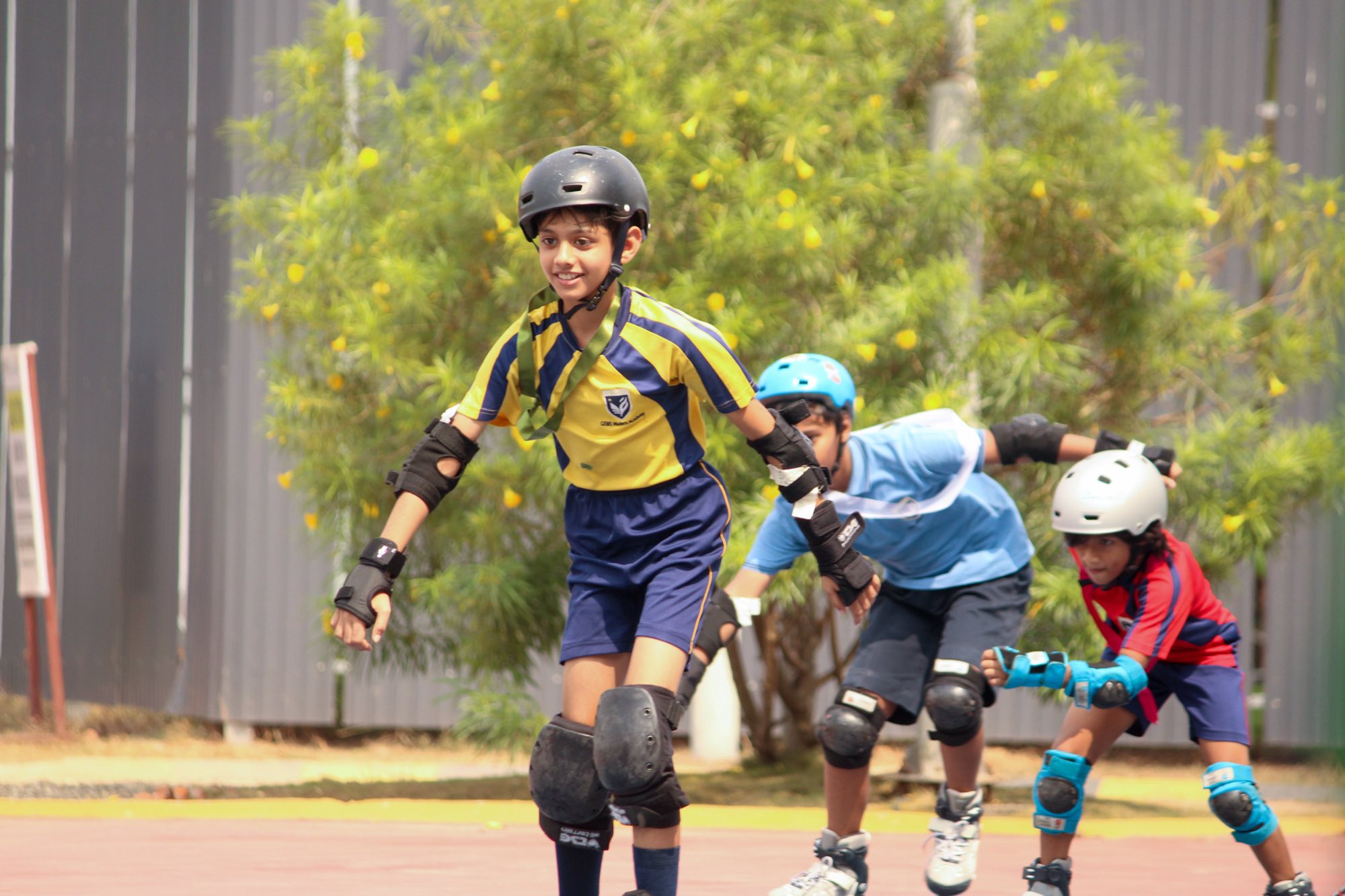 Students in helmets and pads roller skating
